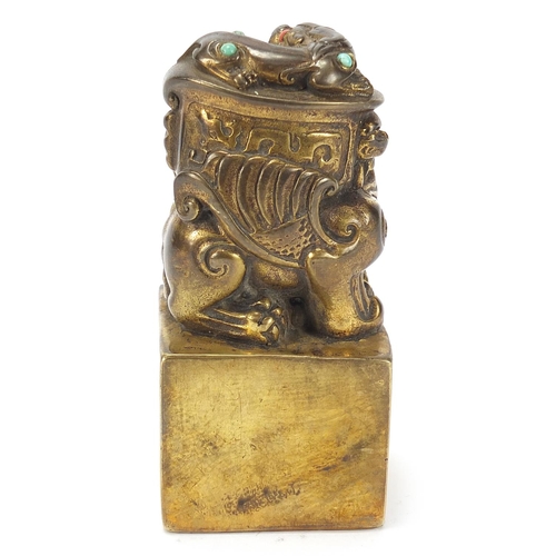 168 - Chinese patinated bronze dog of Foo seal set with turquoise and coral coloured stones, 12cm high