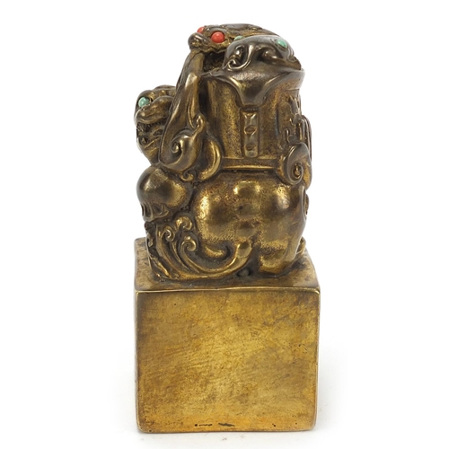 168 - Chinese patinated bronze dog of Foo seal set with turquoise and coral coloured stones, 12cm high