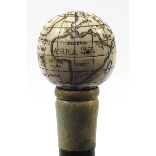 879 - Hardwood walking stick with carved bone globe handle opening to reveal compass, 84cm in length