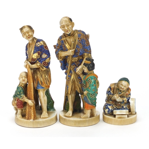 652 - Three Japanese Satsuma pottery figures including two of a father with child, the largest 18.5cm high