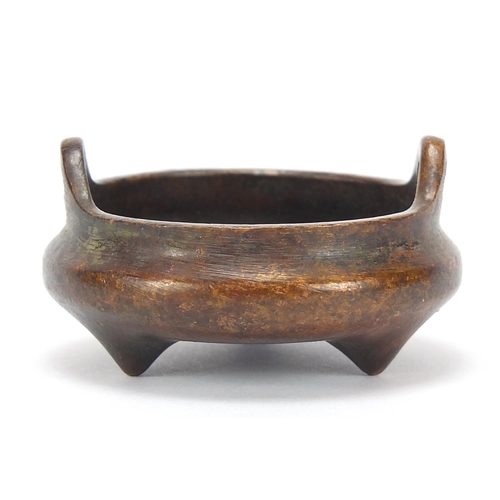 2043 - Chinese patinated bronze tripod censer with twin handles, character marks to the base, 5.5cm in diam... 