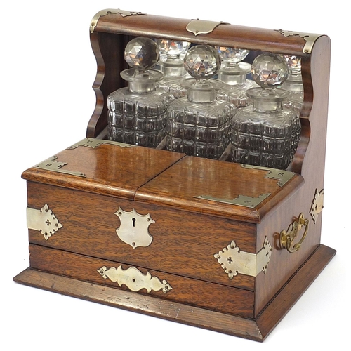 32 - Victorian oak tantalus compendium with metal mounts and carrying handles fitted with three glass bot... 