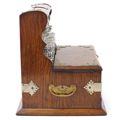 32 - Victorian oak tantalus compendium with metal mounts and carrying handles fitted with three glass bot... 