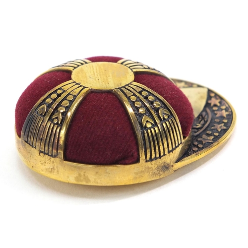 2076 - Novelty brass pin cushion in the form of a jockey's cap, 5cm in length