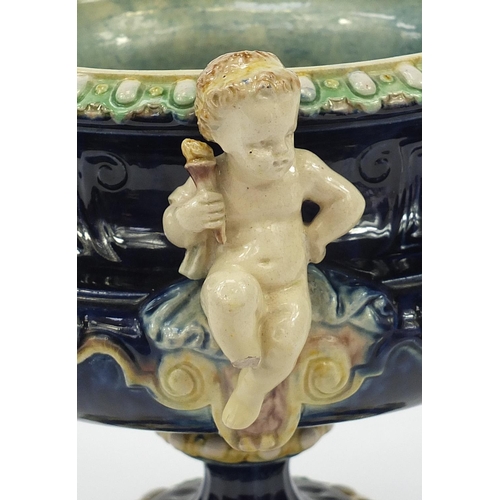 290 - 19th century Majolica centrepiece with twin handles  surmounted with two Putti, 27.5cm high x 33.5cm... 