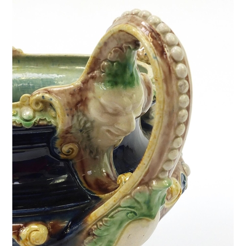 290 - 19th century Majolica centrepiece with twin handles  surmounted with two Putti, 27.5cm high x 33.5cm... 