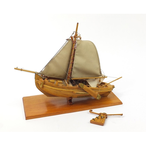 1018 - Large wooden model boat with canvas sails raised on a plinth base, 58cm in length