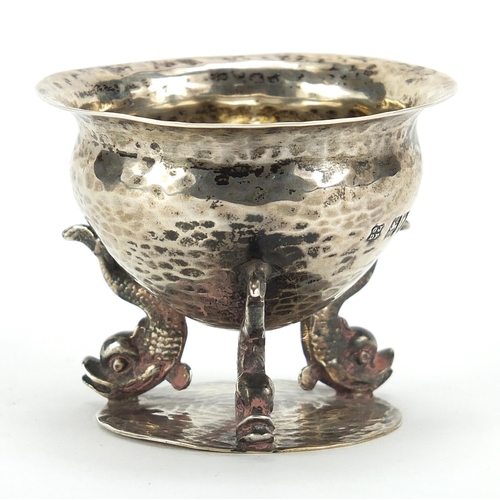 516 - Josiah Williams & Co, Arts & Crafts silver table salt with planished body and three dolphin supports... 