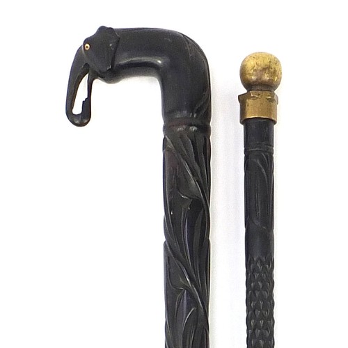 883 - Two Indian ebony walking sticks including one with carved elephant head handle, the largest 87cm in ... 