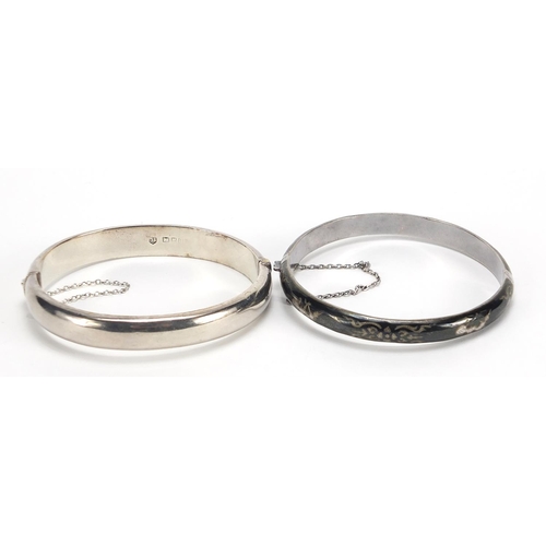 2101 - Two silver hinged bangles including one with Niello work, total 30.2g