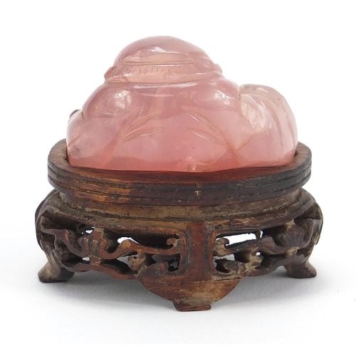 257 - Chinese rose quartz carving of Buddha raised on a carved hardwood stand, 5.5cm wide