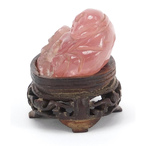 257 - Chinese rose quartz carving of Buddha raised on a carved hardwood stand, 5.5cm wide