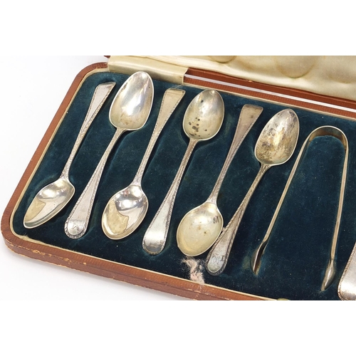 1121 - Matched set of twelve silver teaspoons and silver plated sugar tongs housed in a velvet and silk lin... 