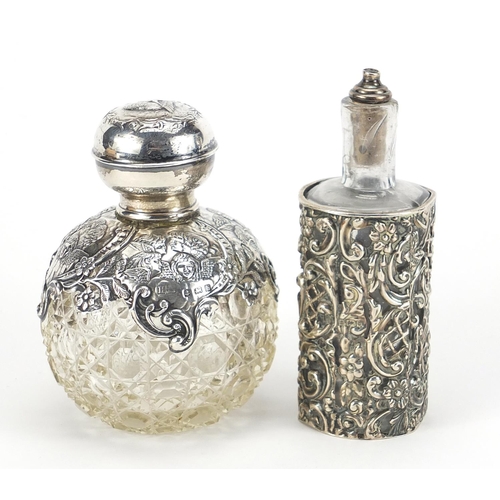 790 - Henry Matthews, two Edwardian silver overlaid cut glass scent bottles embossed with Putti and foliag... 