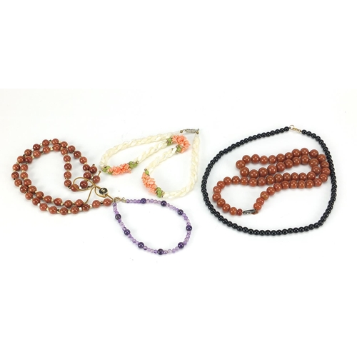 2558 - Four necklaces and an amethyst bracelet with 9ct gold clasp including goldstone and carnelian with s... 