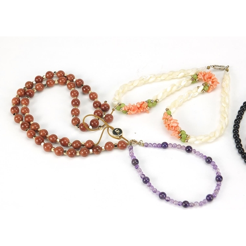 2558 - Four necklaces and an amethyst bracelet with 9ct gold clasp including goldstone and carnelian with s... 