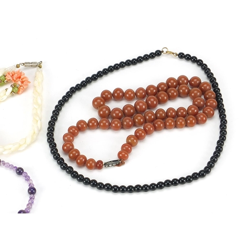 2558 - Four necklaces and an amethyst bracelet with 9ct gold clasp including goldstone and carnelian with s... 