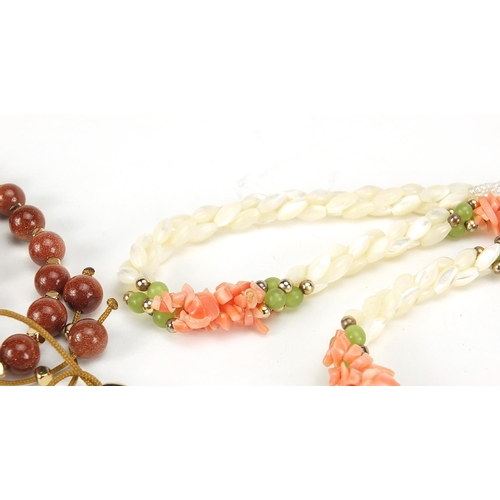 2558 - Four necklaces and an amethyst bracelet with 9ct gold clasp including goldstone and carnelian with s... 