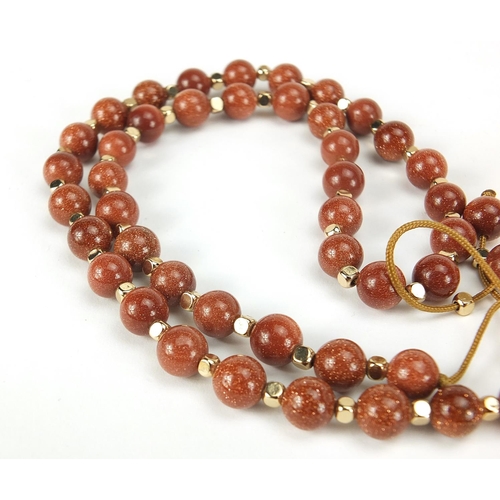 2558 - Four necklaces and an amethyst bracelet with 9ct gold clasp including goldstone and carnelian with s... 