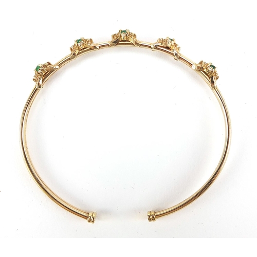 825 - 9ct gold green and clear stone bangle housed in a IK Collection box, 6.5cm wide, 8.9g