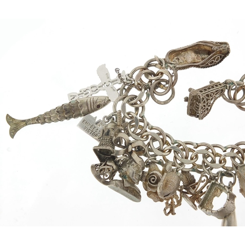 526 - Silver charm bracelet with large selection of mostly silver charms including bust of William Shakesp... 