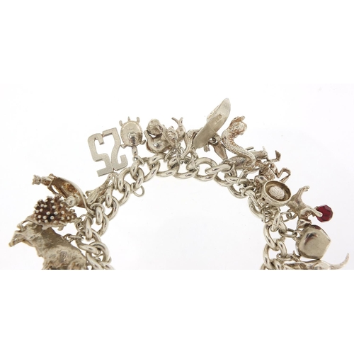 491 - Silver charm bracelet with a selection of mostly silver animal charms including bull, elephant, croc... 