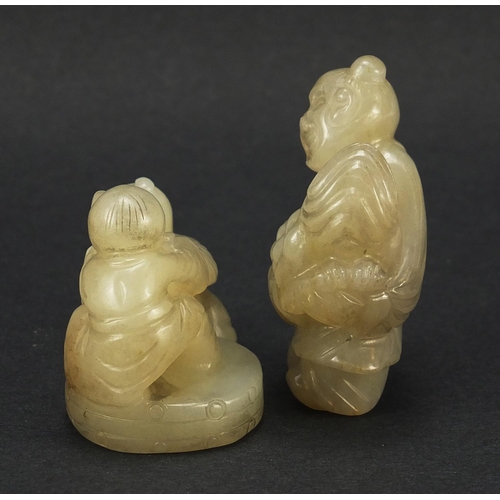 594 - Two Chinese celadon and russet jade carvings including one of a figure holding fruit, the largest 4.... 