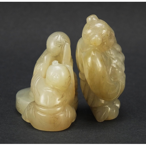 594 - Two Chinese celadon and russet jade carvings including one of a figure holding fruit, the largest 4.... 