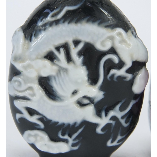 2423 - Four Chinese snuff bottles including a cameo glass example, the largest 7.5cm high