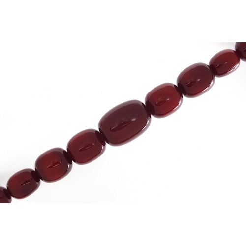 416 - Very large cherry amber coloured bead necklace, the largest bead 4cm in length, 52cm in length, 203.... 