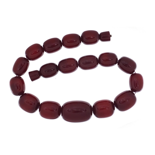 416 - Very large cherry amber coloured bead necklace, the largest bead 4cm in length, 52cm in length, 203.... 