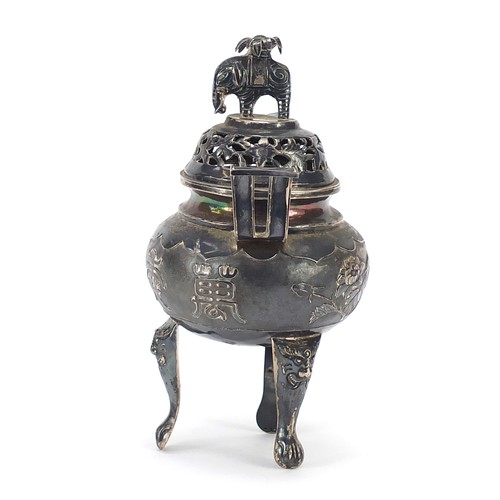 600 - Chinese silver three footed Koro with twin handles and a cover with elephant knop, embossed with flo... 