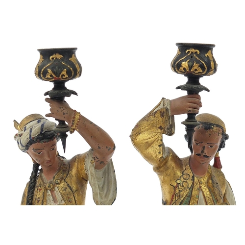 644 - Pair of cold painted spelter figural candlesticks of Middle Eastern figures wearing traditional dres... 