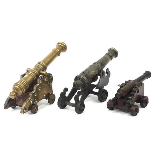 515 - Three antique and later bronze and wooden table cannons including one with engraved barrel, 24cm in ... 