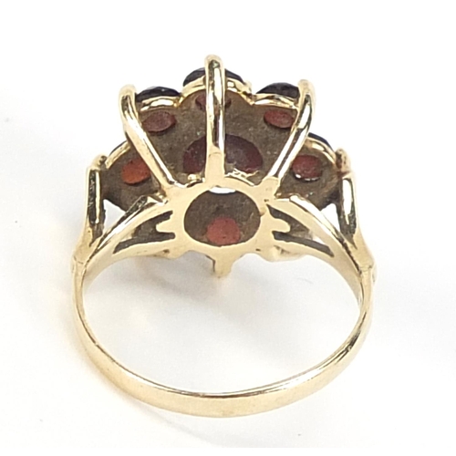 552 - Large 9ct gold garnet flower head ring, the head 1.6cm in diameter, size N, 4.6g