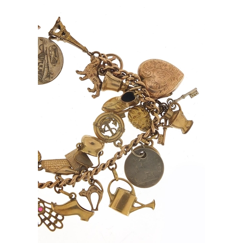 94 - 9ct gold charm bracelet with a selection of gold and metal charms including watering can, hand of Fa... 