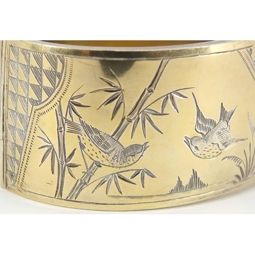 242 - Victorian aesthetic silver gilt hinged bangle engraved with birds amongst bamboo, Birmingham 1886, 6... 