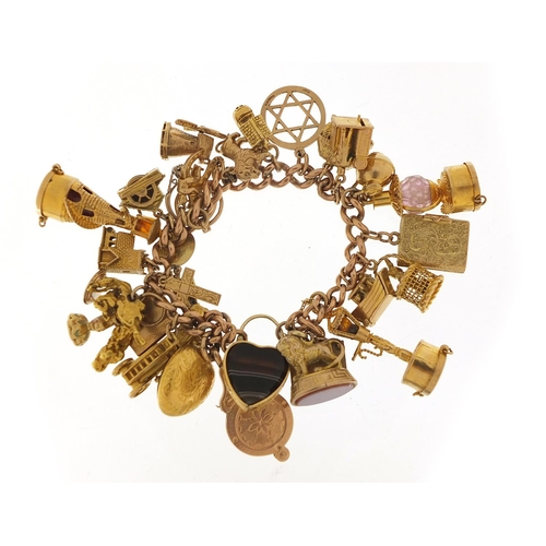 151 - Good 9ct gold charm bracelet with a large selection of mostly gold charms including agate love heart... 