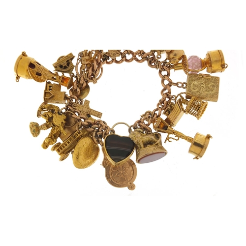 151 - Good 9ct gold charm bracelet with a large selection of mostly gold charms including agate love heart... 