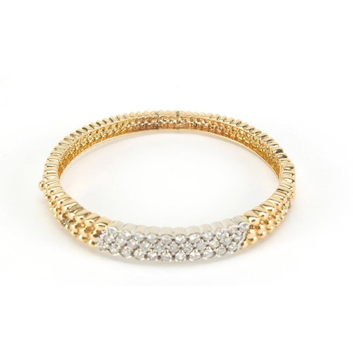 109 - 14ct gold diamond three row hinged bangle, set wit thirty three diamonds, the diamonds approximately... 