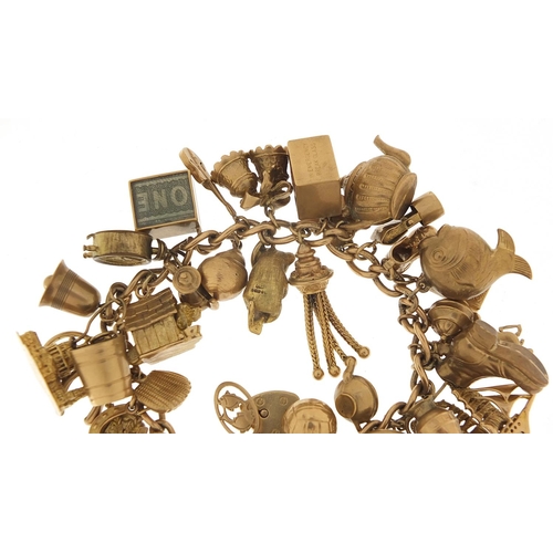 174 - Good 9ct gold charm bracelet with a large selection of mostly gold charms including a rigged sailing... 