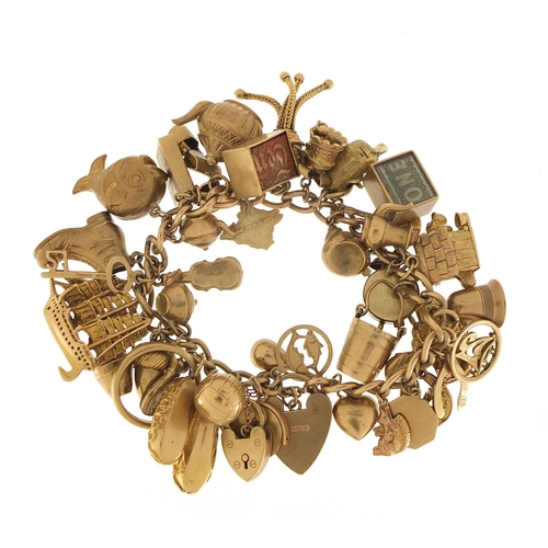 174 - Good 9ct gold charm bracelet with a large selection of mostly gold charms including a rigged sailing... 