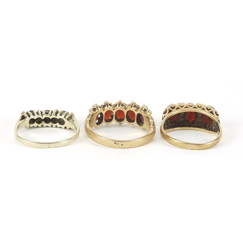 126 - Three 9ct gold rings comprising two with garnets and one with sapphires and diamonds, sizes L, Q and... 