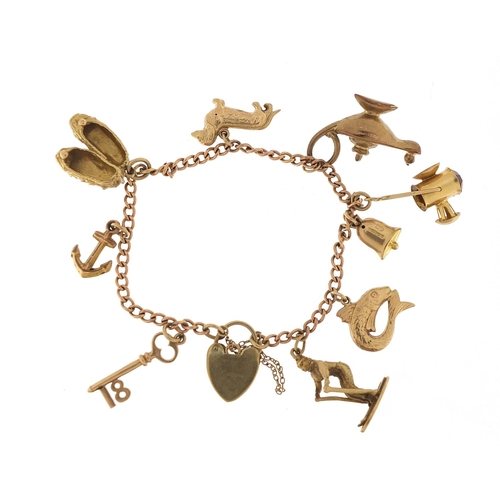 123 - 9ct gold charm bracelet with a selection of mostly 9ct gold charms including Genie oil lamp, skiing ... 