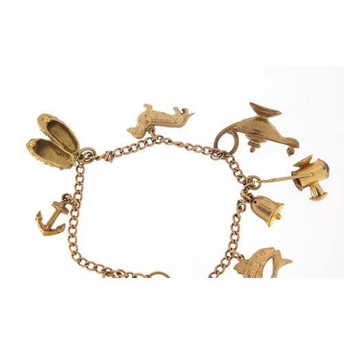 123 - 9ct gold charm bracelet with a selection of mostly 9ct gold charms including Genie oil lamp, skiing ... 