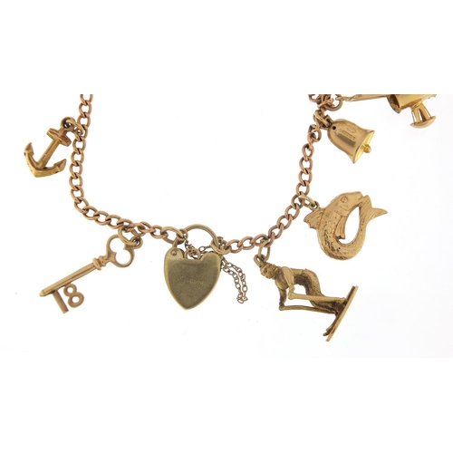 123 - 9ct gold charm bracelet with a selection of mostly 9ct gold charms including Genie oil lamp, skiing ... 