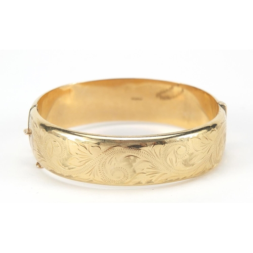 125 - 9ct gold hinged bangle with engraved decoration, Birmingham 1994, 6.2cm in diameter, 1.5cm wide, 17.... 