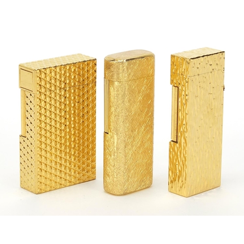 506 - Three vintage gold plated pocket lighters comprising Dunhill with fitted case, S J Dupont and Magie ... 