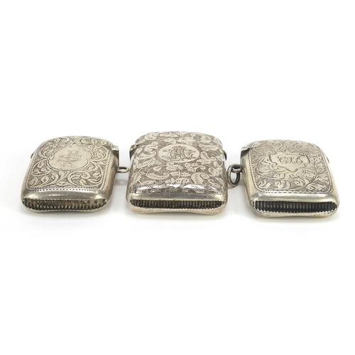 632 - Two Victorian and later silver vestas and a silver coloured metal example, each engraved with vines,... 