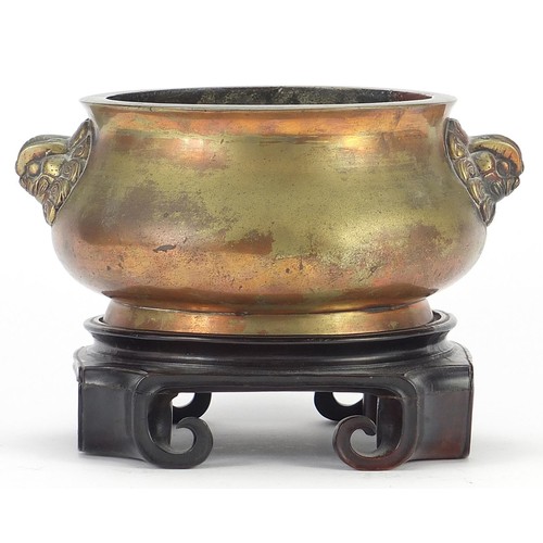 522 - Large Chinese patinated bronze censer with animalia handles raised on a carved hardwood stand, six f... 